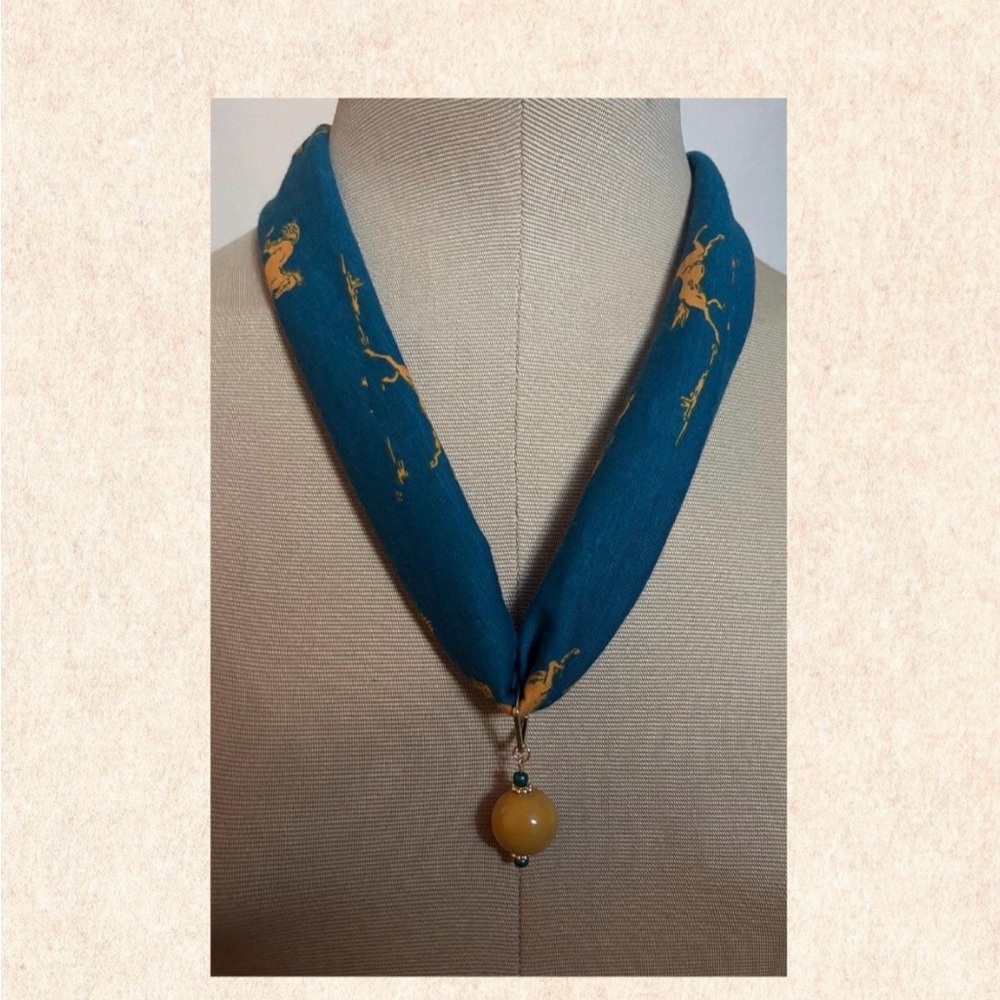 Bronze horse-print jersey fabric necklace with amber ceramic bead pendant.